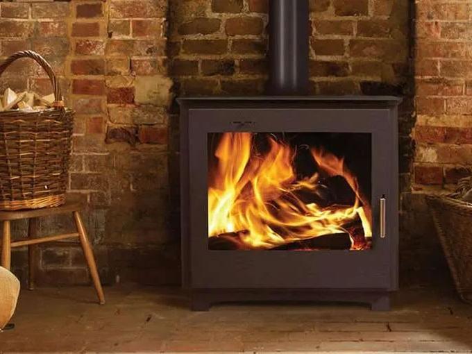 wood burning in stove with exposed brick wall