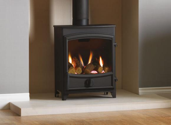 Freestanding gas fire stove in fireplace alcove